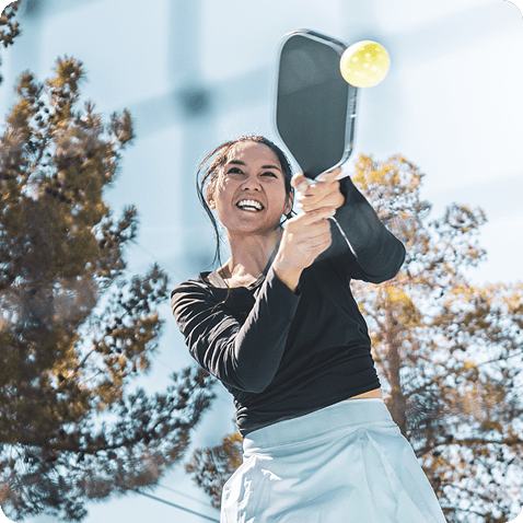 Player hitting pickleball backhand drive