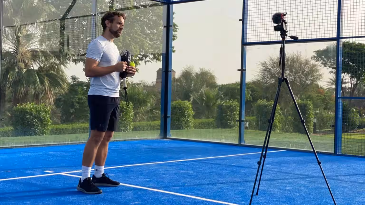 A coach from The Padel School presenting a lesson to camera on an outdoor padel court